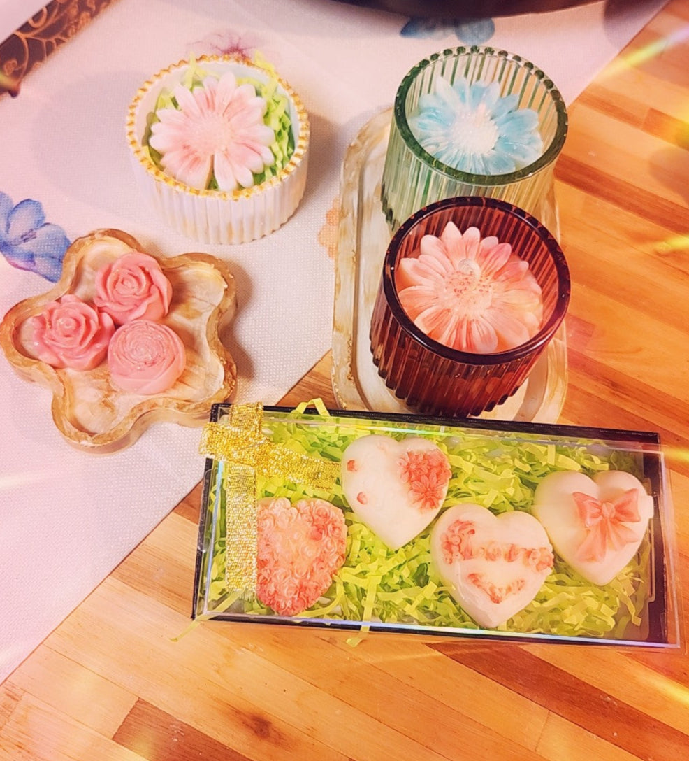 Decorative candles and soaps with floral designs on a wooden surface